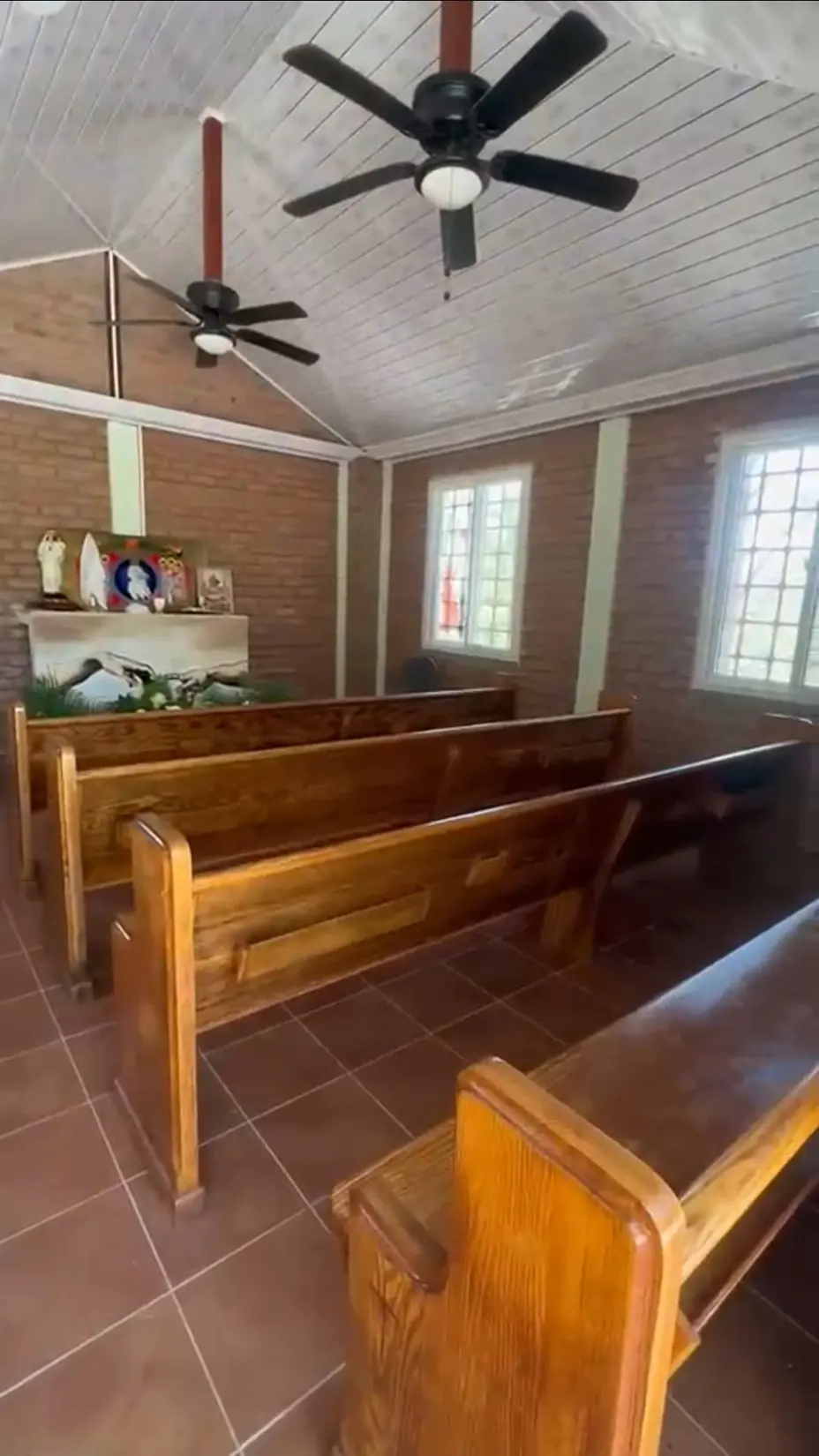 Interior de la capilla, con bancas de madera y altar